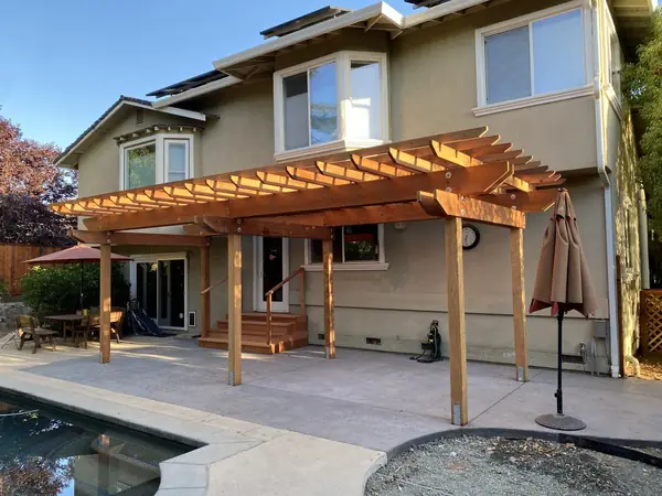 Cedar pergola over a concrete pool deck